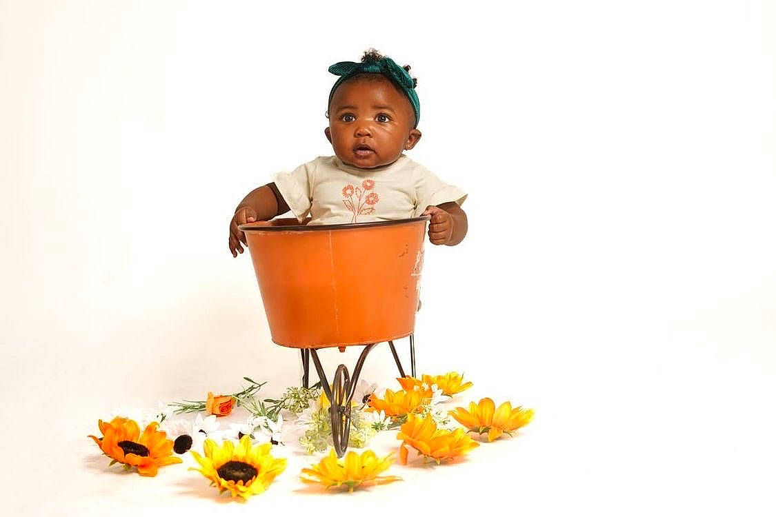 Kross is registered to the contest to win money with this photo: baby, baby_products, baby_safety, baby_toddler_clothing, basket, cart, child, dress, fashion_accessory, flower, happy, natural_foods, orange, people_in_nature, person, petal, plant, sitting, sleeve, toddler