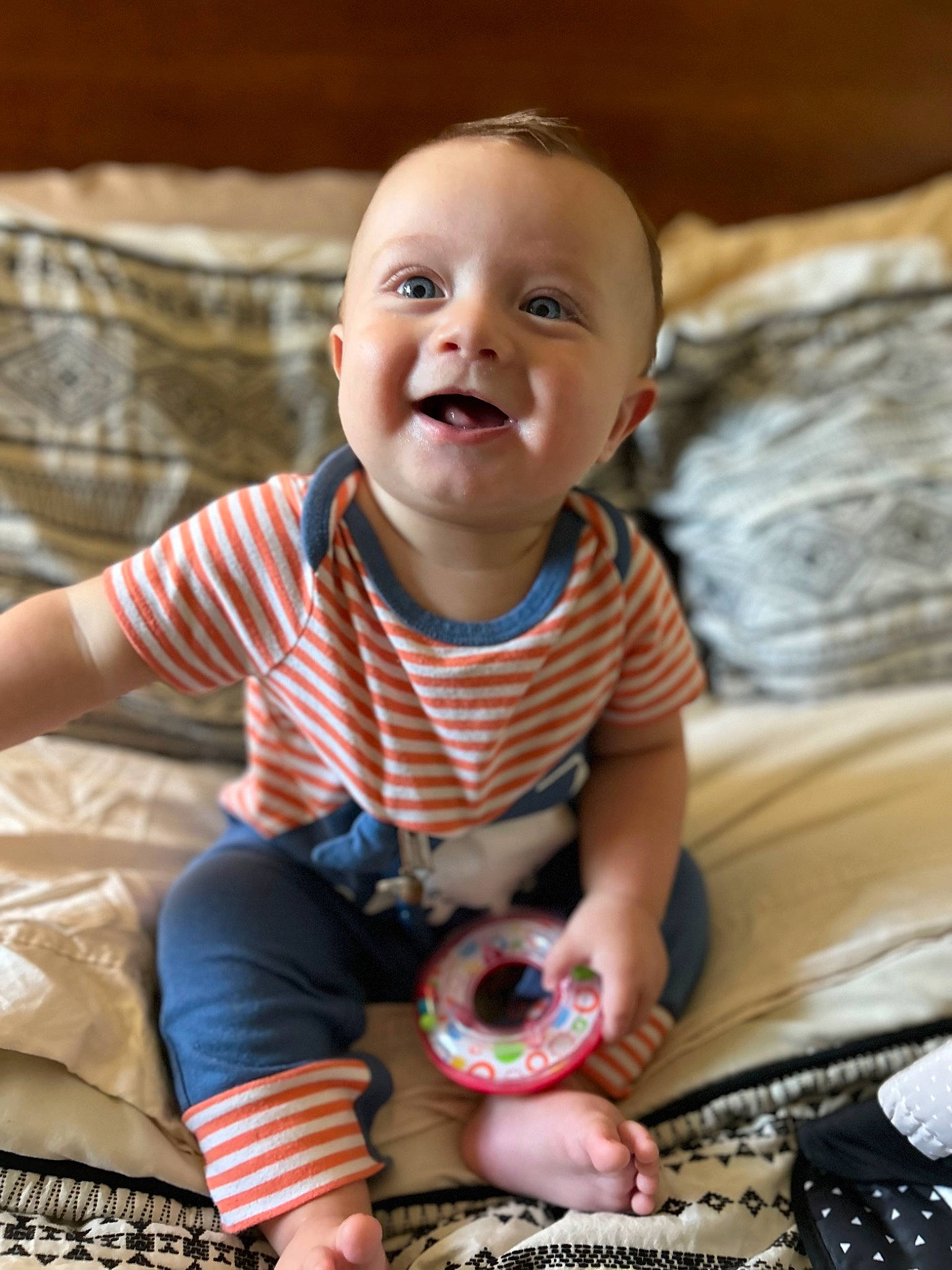 Clyde is registered to the contest to win money with this photo: arm, baby, baby_toddler_clothing, cheek, child, face, finger, fun, happy, iris, linens, mouth, pattern, person, sitting, skin, sleeve, smile, t_shirt, toddler