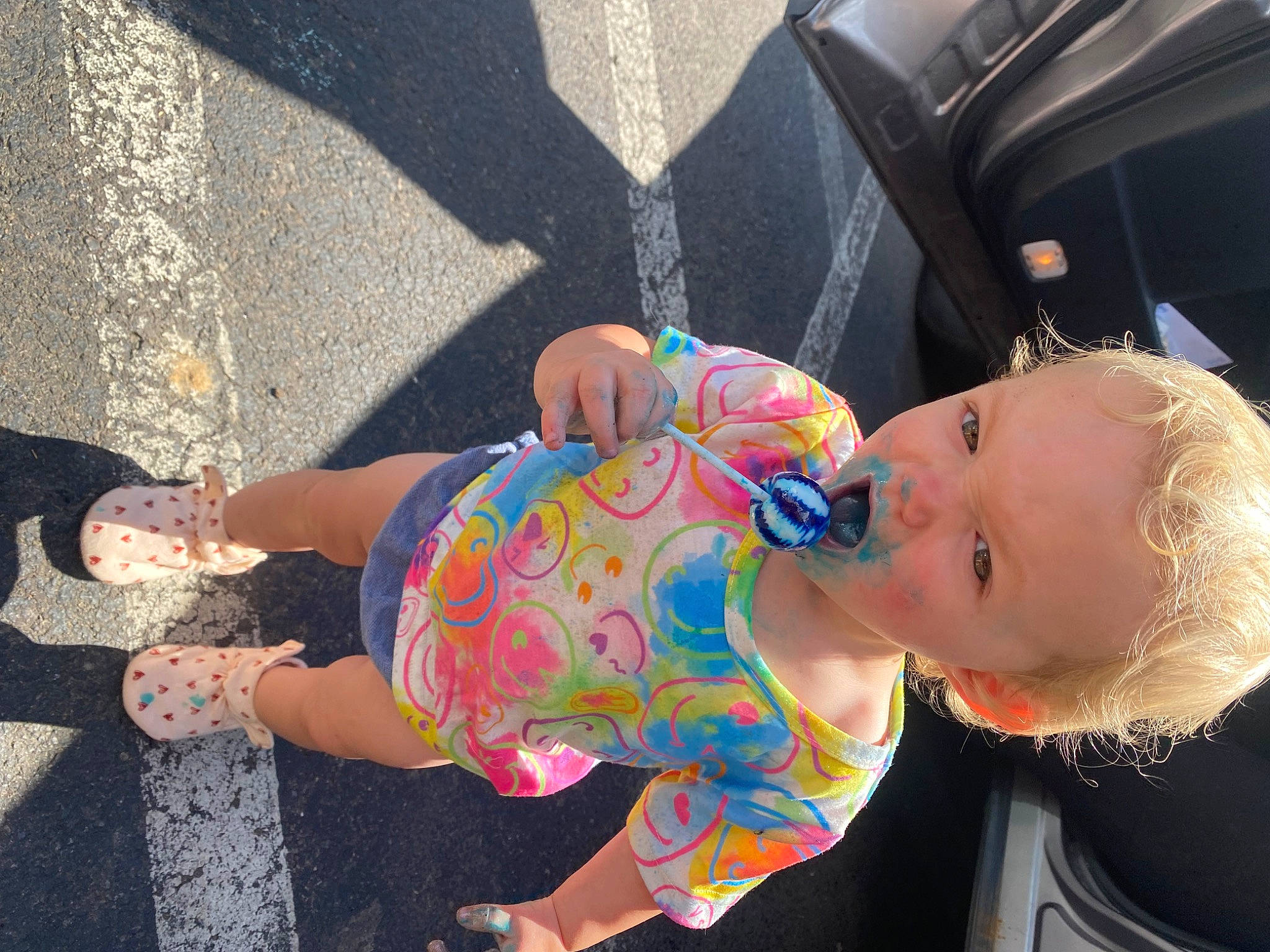 Violette is registered to the contest to win money with this photo: asphalt, baby, child, eyewear, finger, foot, fun, human_leg, leisure, pattern, person, pink, recreation, road_surface, sandal, sidewalk, sitting, thigh, toddler, vacation