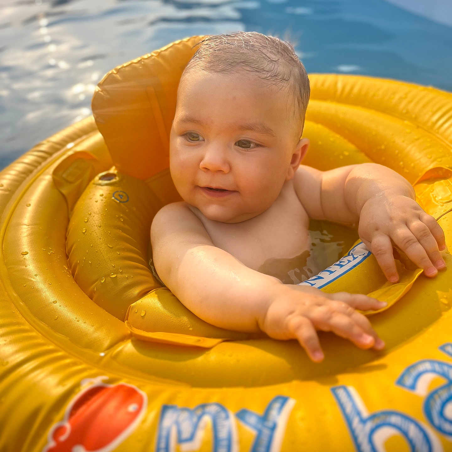 Manasse a rejoint le concours — aidez-le/la à gagner de superbes lots ! arms, baby, child, closeup, cute, face, floating, happy, infant, inflatable_ring, outdoor, playful, pool, skin, summer, sunlight, swimming, water, wet_hair, yellow