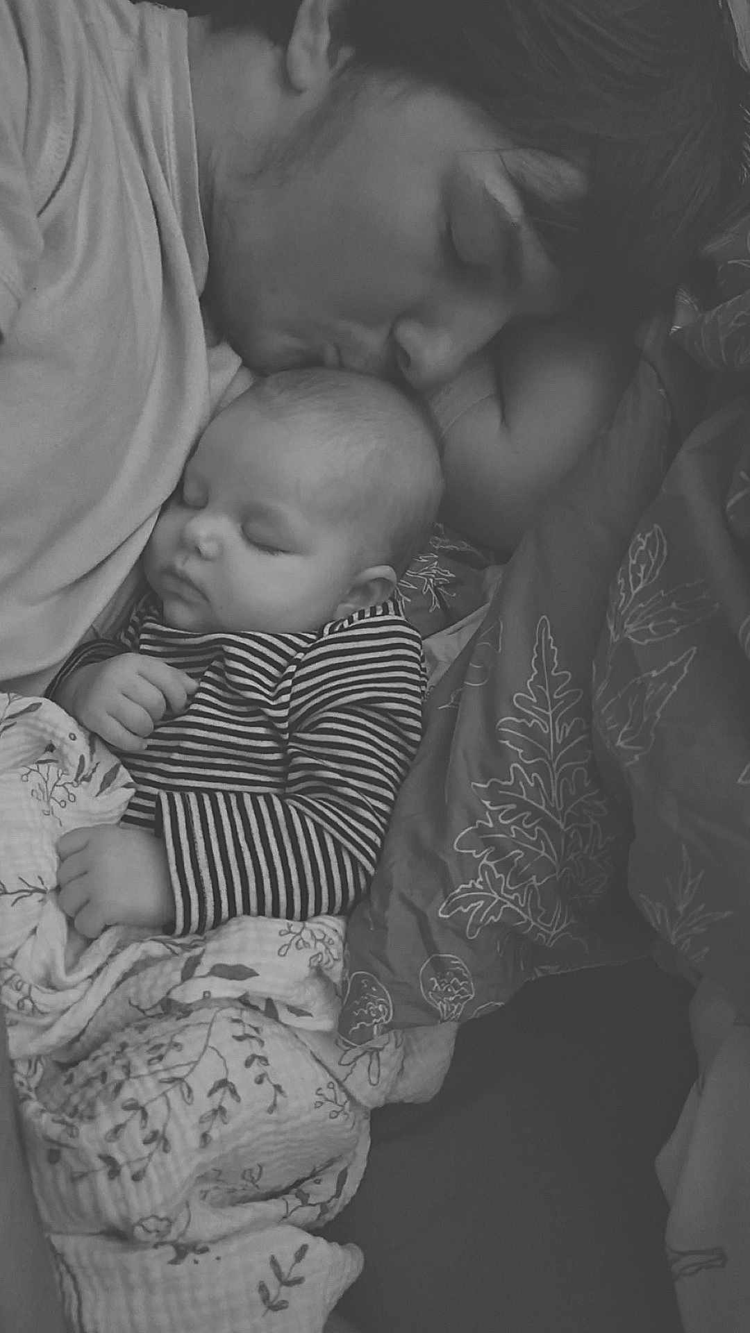 Ivory is registered to the contest to win money with this photo: baby, adult, sleeping, kiss, black_and_white, blanket, striped_clothing, close_up, face, peaceful, resting, bed, cuddle, comfort, love, portrait, gentle, parent, child, cozy