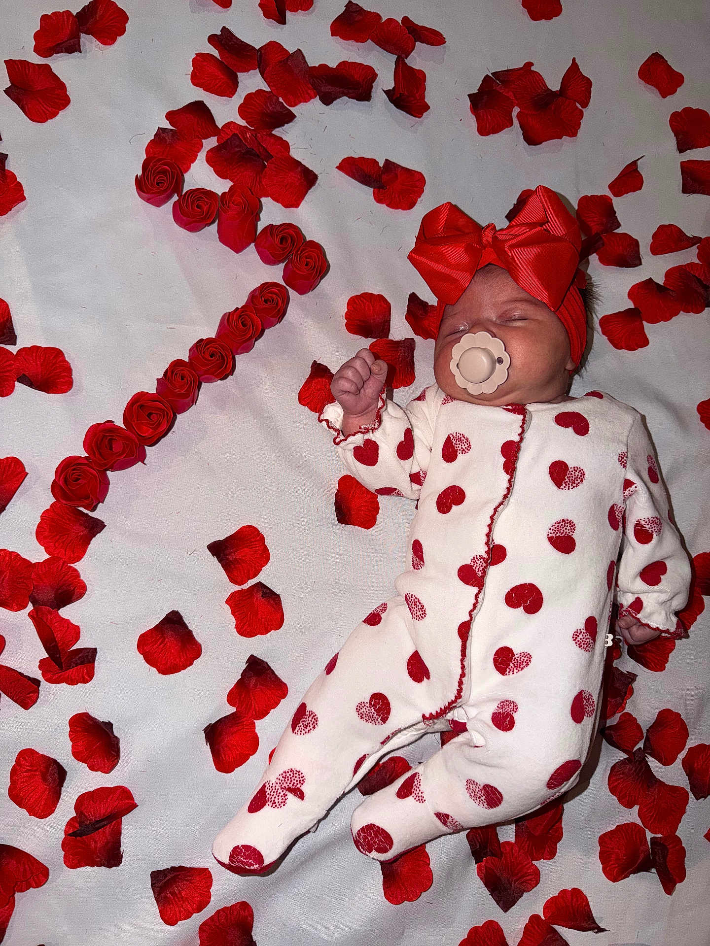 Romy a rejoint le concours — aidez-le/la à gagner de superbes lots ! baby, infant, onesie, red_bow, pacifier, rose_petals, red_hearts, sleeping, lying_down, bed, flower_arrangement, celebration, cute, soft_fabric, headband, number_two, decor, portrait, toddler, peaceful