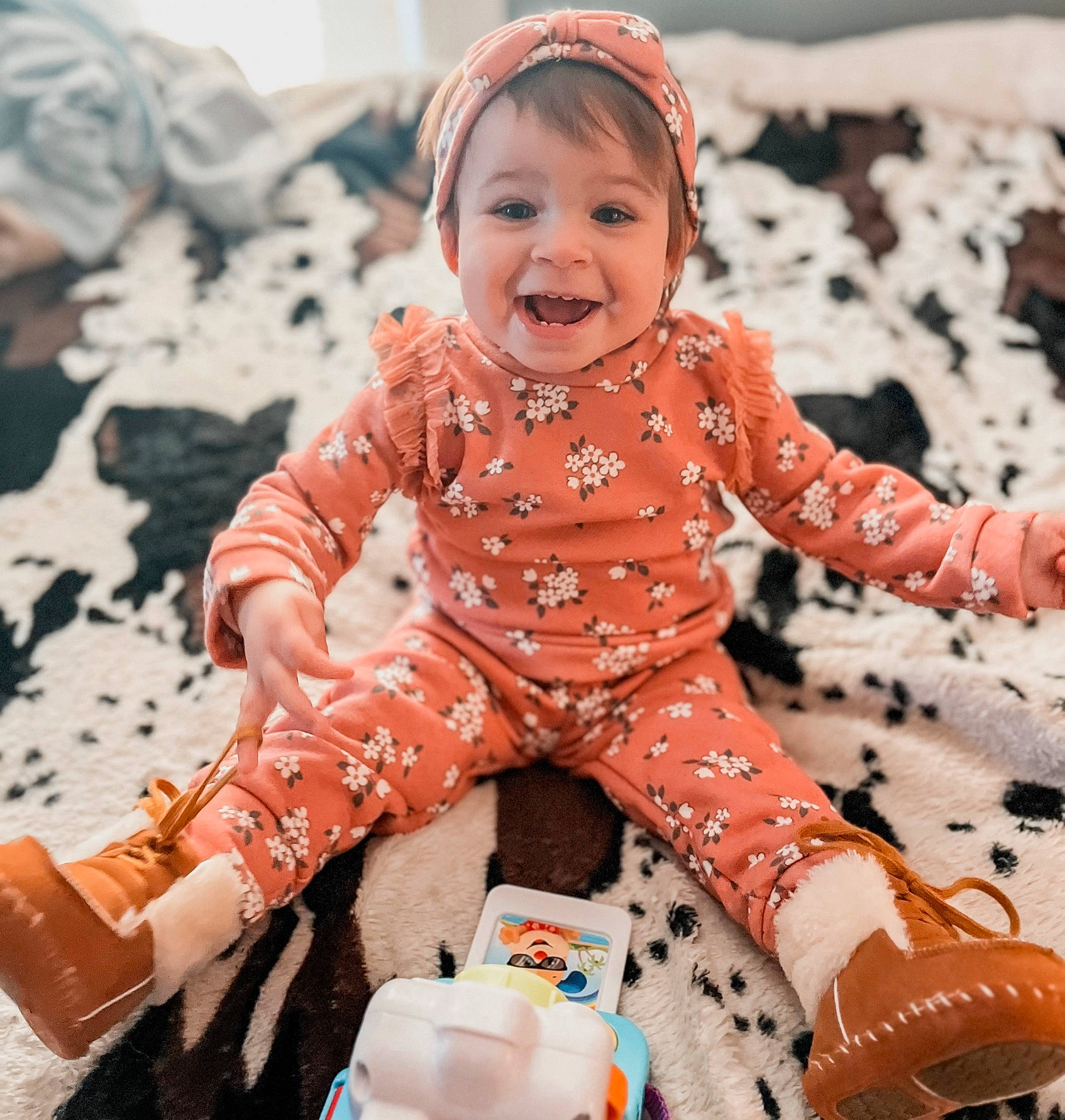 Sutton is registered to the contest to win money with this photo: baby, baby_toddler_clothing, cheek, cool, eye, face, happy, head, human_body, leg, orange, person, photograph, pink, red, skin, sleeve, smile, textile, toddler
