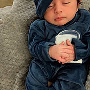 Aliyan is registered to the contest to win money with this photo: baby, sleeping, blue_clothing, hat, blanket, soft_texture, infant, peaceful, hands_clasped, bare_feet, indoors, cozy, cute, portrait, child, resting, newborn, comfort, warm, relaxed