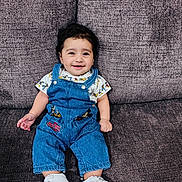 Aliyan joined the competition — help win amazing prizes! baby, child, smiling, denim_overalls, mickey_mouse, sneakers, couch, purple, seated, happy, face, clothing, footwear, indoor, person, cute, young, infant, portrait, casual