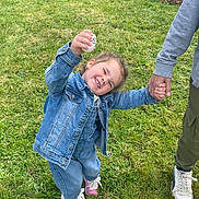Ana a rejoint le concours — aidez-le/la à gagner de superbes lots ! child, girl, denim_jacket, pink_shoes, grass, outdoor, flower_bed, holding_hand, egg, smiling, happy, casual_clothing, spring, playful, person, adult_hand, nature, greenery, plants, tire_planter
