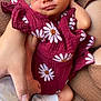 baby, newborn, infant, sleeping, maroon_clothing, daisy_pattern, hand, bottle, feeding, sock, cozy, brown, fabric, couch, resting, cute, peaceful, person, skin, closeup