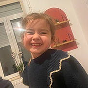 Amy participe au concours pour gagner de l'argent avec cette photo : child, smile, indoor, window, light_flare, sweater, gold_trim, young, happy, face, person, home, plant, shelf, decor, casual, portrait, cute, girl, warm