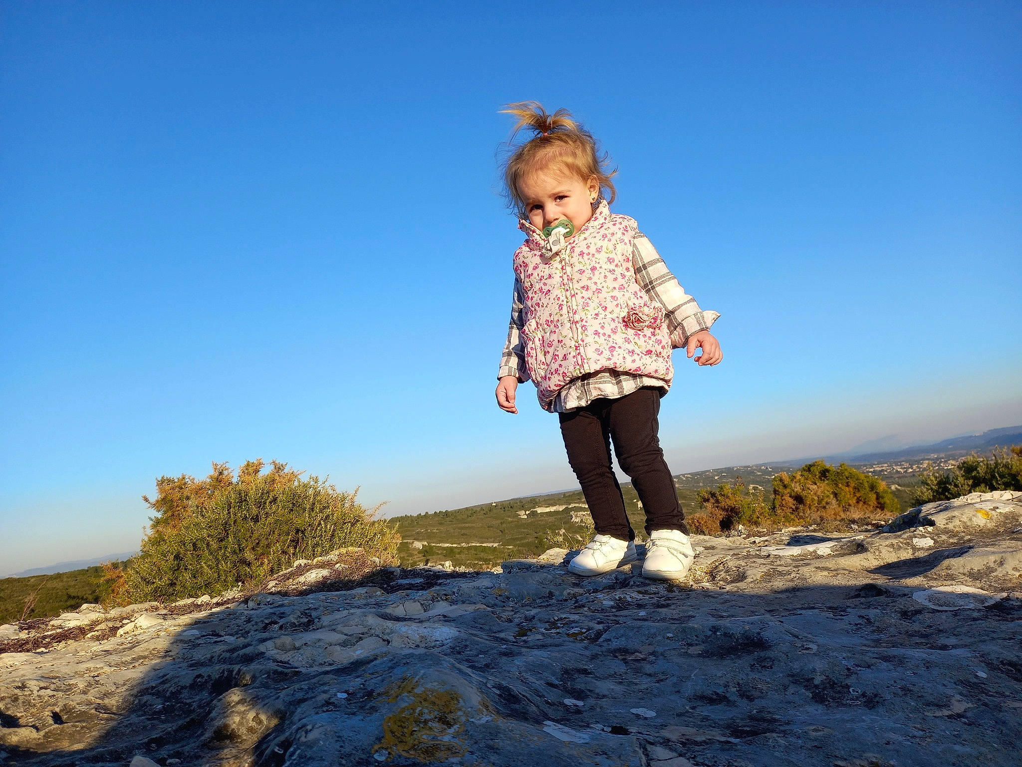 Clara participe au concours pour gagner de l'argent avec cette photo : azure, body_of_water, ecoregion, flash_photography, fun, gesture, grass, happy, horizon, landscape, leisure, people_in_nature, person, recreation, sand, sky, standing, sunlight, toddler, travel