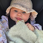 Nina a rejoint le concours — aidez-le/la à gagner de superbes lots ! baby, infant, face, hat, clothing, blanket, child, cute, portrait, closeup, expression, blue_eyes, soft, fluffy, cozy, car_seat, young, skin, hand, person