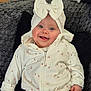 baby, blue_eyes, cherry_pattern, child, cozy, cute, face, hands, happy, indoors, infant, portrait, sitting, smiling, soft_blanket, towel_bow, warm, wearing_hood, white_clothing, young_child