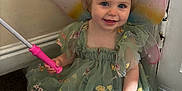 Evelyn is registered to the contest to win money with this photo: toddler, child, fairy_wings, dress, green_dress, smiling, indoor, carpet, wand, hair_clips, cute, girl, costume, playful, portrait, sitting, happy, young_child, magic, imaginative_play