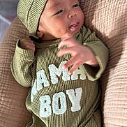 Kyren joined the competition — help win amazing prizes! baby, infant, child, green_clothing, knit_hat, knit_outfit, cushion, soft_texture, lying_down, hand, expression, face, portrait, indoors, cozy, cute, warm_colors, baby_boy, comfortable, closeup