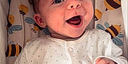Abel joined the competition — help win amazing prizes! baby, infant, smiling, happy, onesie, white_clothing, patterned_background, bee_pattern, cute, child, face, hand, portrait, lying_down, indoor, soft_lighting, newborn, closeup, expression, joy