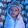 Abel joined the competition — help win amazing prizes! baby, infant, towel, hat, face, eyes, expression, cushion, pattern, elephant, blue_light, wrapped, cute, child, portrait, indoors, comfortable, soft_texture, clothing, newborn