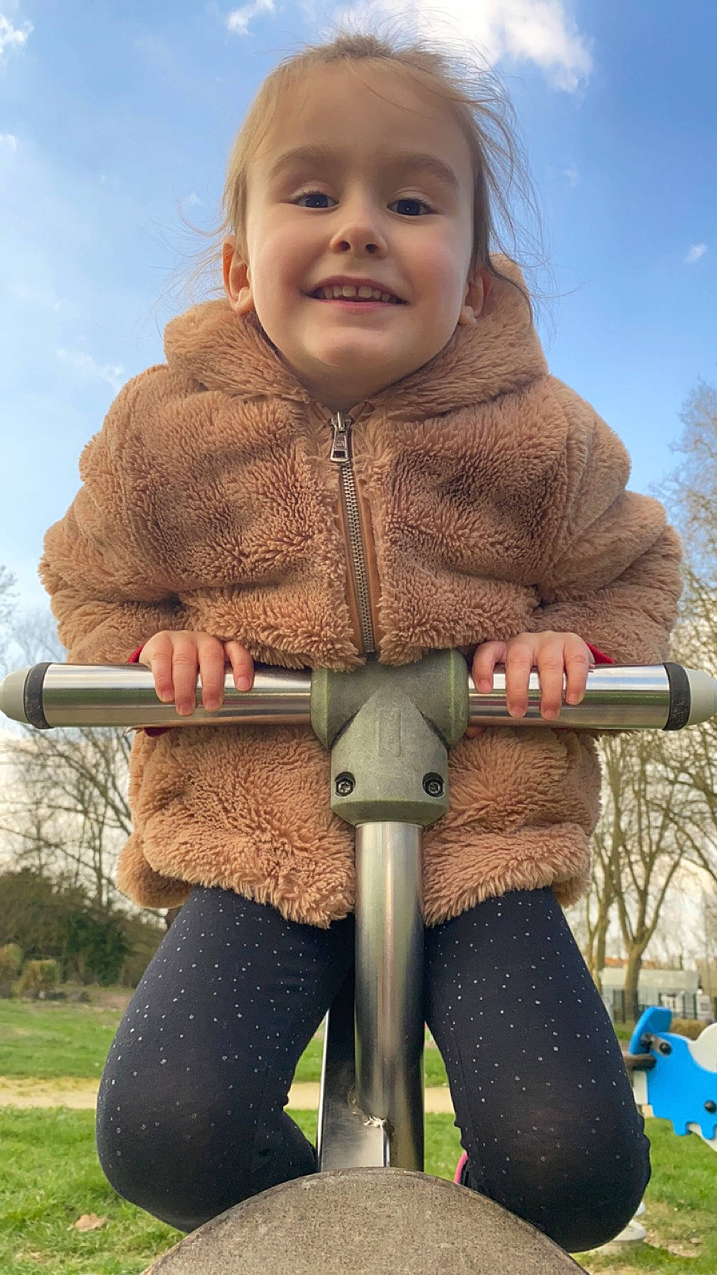 Héloïse a rejoint le concours — aidez-le/la à gagner de superbes lots ! blond, child, cloud, facial_expression, fun, glove, grass, happy, jacket, joy, leisure, outdoor_play_equipment, people_in_nature, person, plant, recreation, sky, sleeve, smile, standing
