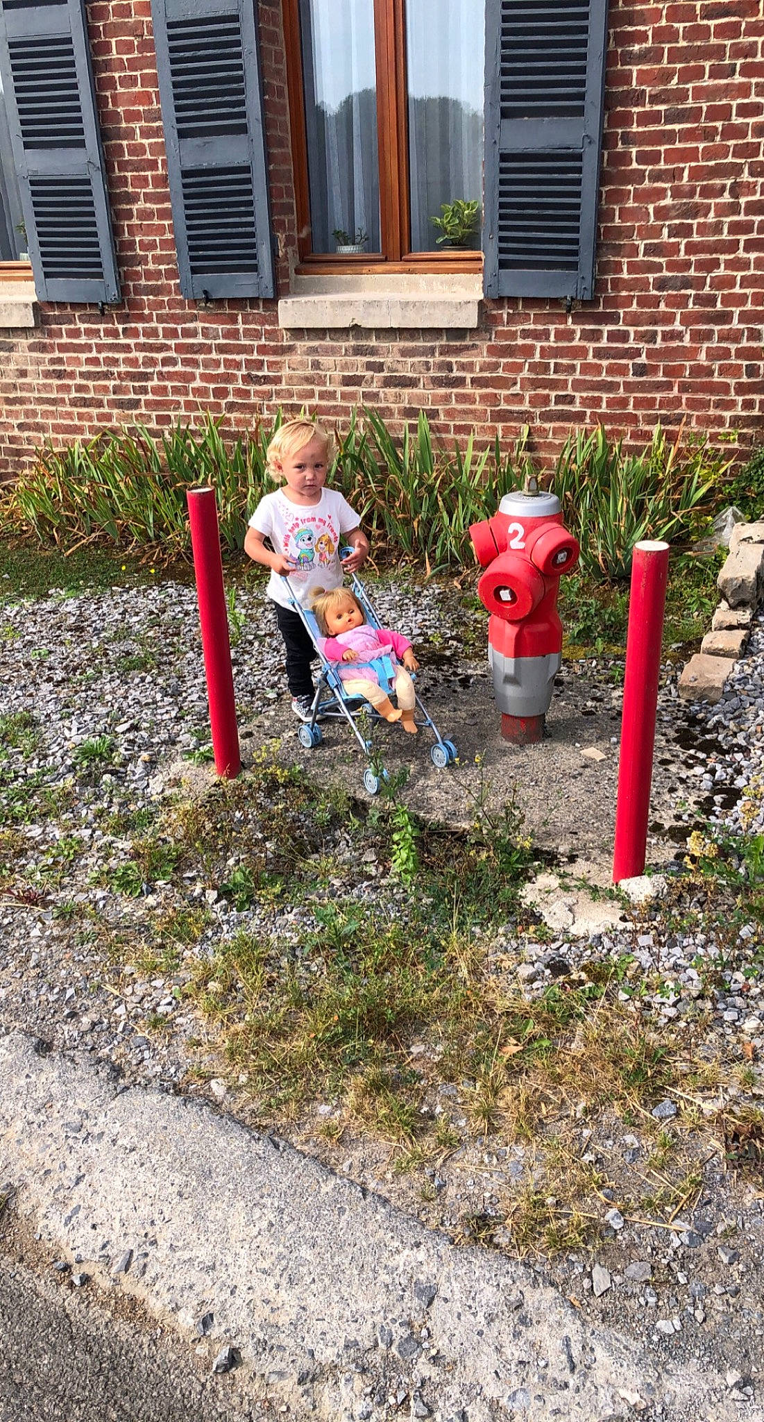 Maelys participe au concours pour gagner de l'argent avec cette photo : asphalt, brick, brickwork, concrete, driveway, fire_hydrant, grass, groundcover, house, landscape, landscaping, lawn, leisure, person, plant, road_surface, shrub, sidewalk, toddler, tree