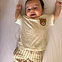 arms_up, baby, barefoot, child, clothing, cute, face, happy, indoors, infant, lying_down, person, portrait, shirt, smile, soft_light, striped_pants, teddy_bear, white_background, young_child