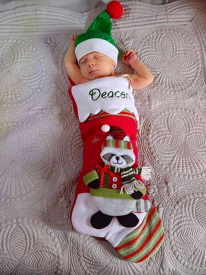 Deacon joined the competition — help win amazing prizes! baby, baby_toddler_clothing, christmas, christmas_eve, costume, costume_accessory, costume_hat, dessert, fictional_character, headwear, holiday, human_body, linens, person, red