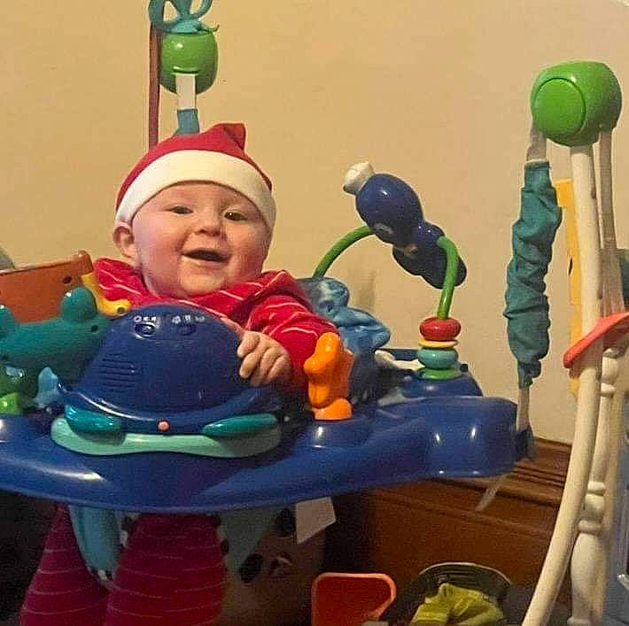 Connor is registered to the contest to win money with this photo: animation, baby, baby_products, baby_toys, cap, child, event, fictional_character, figurine, fun, happy, hat, headwear, holiday, nonbuilding_structure, person, plastic, recreation, room, smile