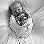 newborn, baby, sleeping, wrapped, blanket, feet, chain, pendant, black_and_white, portrait, infant, peaceful, soft, cute, tiny, resting, closeup, monochrome, cozy, swaddled