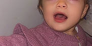 Lyna participe au concours pour gagner de l'argent avec cette photo : child, toddler, sweater, purple, knitwear, indoor, person, face, expression, curly_hair, long_eyelashes, open_mouth, cute, young, portrait, clothing, standing, light_skin, small_hand, curious