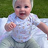 baby, child, smiling, blue_eyes, headband, bow, outdoor, grass, blanket, toy, shirt, pants, socks, playful, happy, infant, cute, portrait, sitting, person