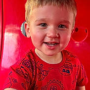 Cameron is registered to the contest to win money with this photo: background, bright_colors, casual_clothing, cheerful, child, closeup, cute, expression, face, fun_pattern, happy, indoors, person, playful, portrait, red_shirt, short_hair, smiling, toddler, young_child