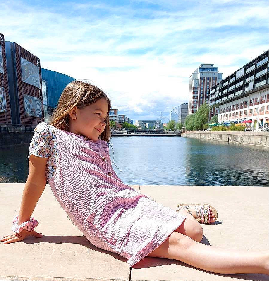 Iria participe au concours pour gagner de l'argent avec cette photo : building, cloud, daytime, elbow, eyewear, flash_photography, grass, happy, joy, knee, lake, leg, leisure, person, sky, sleeve, street_fashion, summer, thigh, travel