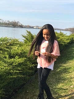 K'Lynn joined the competition — help win amazing prizes! black_hair, brown_hair, denim, fun, grass, grassland, happy, joy, knee, lake, landscape, leisure, long_hair, person, plant, sky, sleeve, t_shirt, travel, waist