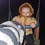 toddler, child, swing, jacket, hood, night, playful, tongue_out, hand, chains, boots, outdoor, cold_weather, person, seat, clothing, holding, fun, dark_background, flash
