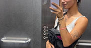 Vegas participe au concours pour gagner de l'argent avec cette photo : black_dog, buttons, casual_clothing, dog, earbuds, elevator, happy_dog, indoor, leash, metal_wall, mirror, phone, portrait, reflection, selfie, shorts, standing, tank_top, tattoos, woman