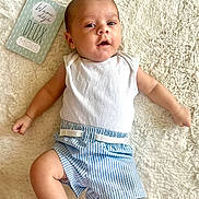 Adriann a rejoint le concours — aidez-le/la à gagner de superbes lots ! baby, infant, milestone_card, blanket, blue_striped_shorts, white_shirt, lying_down, cute, face, arms, legs, skin, head, expression, soft_texture, indoor, child, newborn, comfortable, milestone