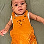 Adriann a rejoint le concours — aidez-le/la à gagner de superbes lots ! baby, infant, orange_overalls, bear_embroidery, white_shirt, lying_down, blanket, curious, wide_eyes, arms, cute, child, portrait, soft_texture, clothing, button, fabric, indoor, person, young_child