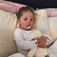 Jennah a rejoint le concours — aidez-le/la à gagner de superbes lots ! child, toddler, pacifier, stuffed_animal, bunny, bed, blanket, pillow, white_clothing, indoors, resting, comfort, soft_toys, young_child, relaxed, cute, sleepwear, home, cozy, portrait