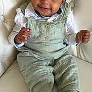 Demik is registered to the contest to win money with this photo: baby, child, smiling, overalls, green_clothing, white_shirt, boots, leather_chair, indoor, cute, portrait, sitting, happy, face, eyes, hands, small_ears, fashion, comfortable, adorable