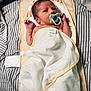 baby, baby_bottle, bed, blanket, cozy, cute, face, hand, indoors, infant, lying_down, newborn, nursery, pacifier, resting, sleeping, soft, striped_bed, towel, wrapped