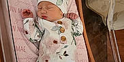 Gracelynn joined the competition — help win amazing prizes! newborn, baby, sleeping, floral_clothing, hat, hospital_bassinet, pink_sheet, birth_announcement, wooden_sign, infant, peaceful, cute, portrait, indoors, person, child, baby_girl, resting, soft_lighting, hospital