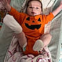Gracelynn joined the competition — help win amazing prizes! baby, infant, onesie, orange_clothing, pumpkin_face, blanket, smiling, cute, happy, lying_down, indoor, child, sock, diaper, soft_toy, playful, young_child, head, face, cozy