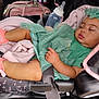 accessory, baby, blanket, bottle, car_seat, child, clothing, cute, footwear, headband, indoors, infant, mint_green_dress, peaceful, person, pink_shoes, resting, seat_belt, sleeping, toddler