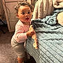 Patience is registered to the contest to win money with this photo: baby, bed, blanket, candid, carpet, carpeted_floor, child, curious, curly_hair, expression, furniture, home, indoor, person, pink_clothing, soft_texture, standing, toddler, toy, white_sock