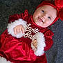 baby, blanket, child, christmas, cozy, cute, festive, floor_tiles, happy, headband, holiday, infant, lying_down, portrait, red_clothing, santa_baby, smiling, tongue_out, velvet, white_trim