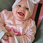 Charlotte a rejoint le concours — aidez-le/la à gagner de superbes lots ! baby, smiling, headband, bow, pink_clothing, star_pattern, infant, happy, cute, child, seatbelt, car_seat, cushion, portrait, indoors, hands, face, blue_eyes, soft_fabric, cozy