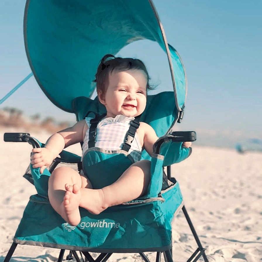 Isabella joined the competition — help win amazing prizes! architecture, baby, beach, building, chair, coast, face, furniture, happy, head, nature, outdoors, person, photography, portrait, sea, shelter, shoreline, sitting, water