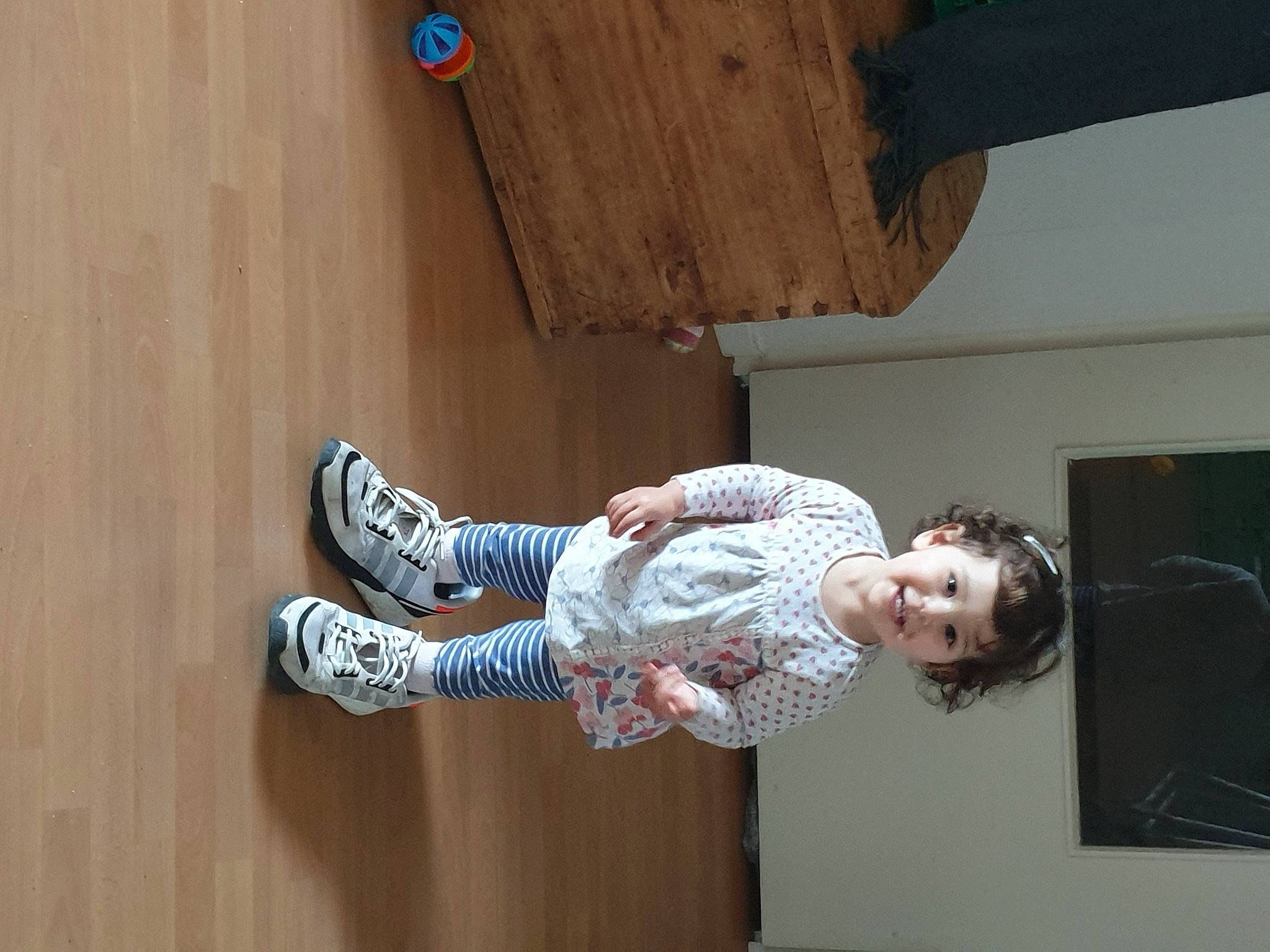 Shaïna participe au concours pour gagner de l'argent avec cette photo : baby_toddler_clothing, ceiling, child, elbow, flooring, foot, fun, happy, hardwood, human_leg, joy, knee, leisure, outdoor_shoe, person, plywood, room, smile, toddler, wood