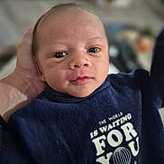 Toakai participe au concours pour gagner de l'argent avec cette photo : baby, newborn, infant, face, hand, clothing, blue, text, closeup, portrait, person, cute, young, indoors, blurred_background, soft_light, expression, eyes, mouth, skin