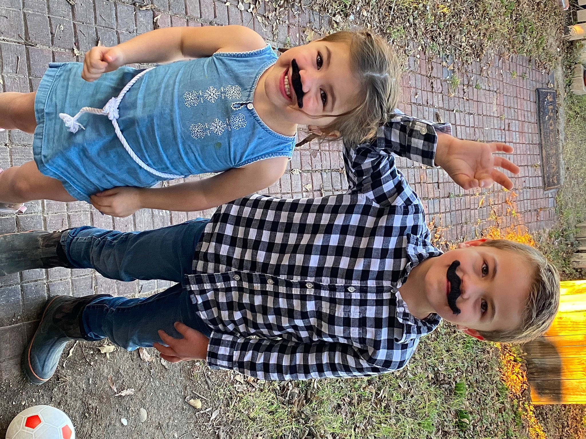 Tesla is registered to the contest to win money with this photo: blue, child, clothing, cool, eyewear, fun, gesture, grass, happy, human_leg, joy, leisure, pattern, people_in_nature, person, plaid, recreation, sitting, smile, t_shirt