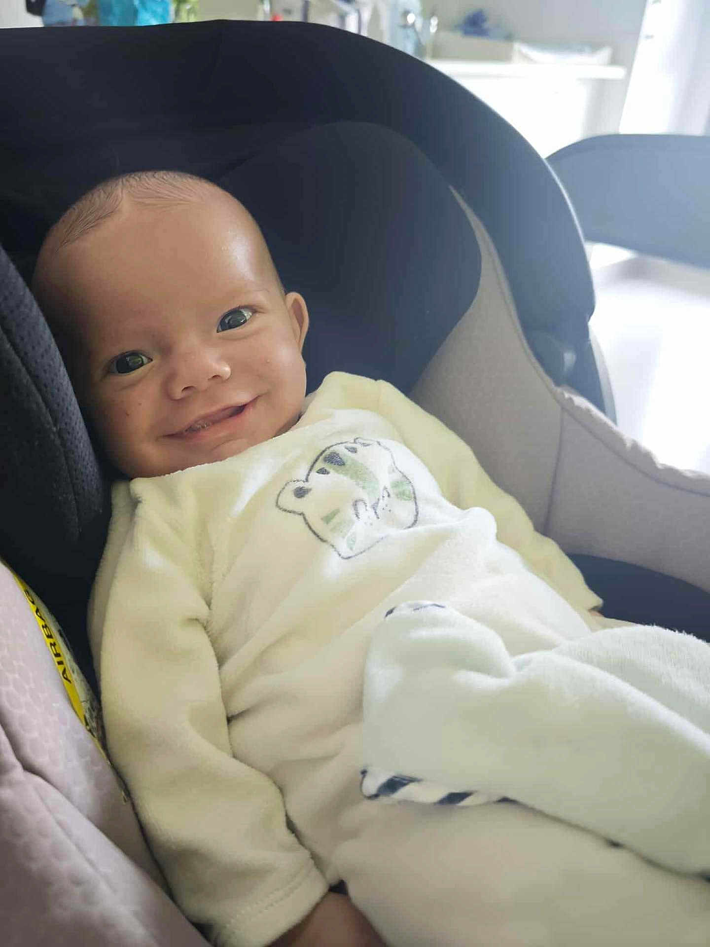 Malo participe au concours pour gagner de l'argent avec cette photo : baby, smile, car_seat, white_outfit, blanket, infant, child, indoors, portrait, cute, comfort, seat, happy, face, clothing, person, soft_lighting, baby_girl, baby_boy, newborn