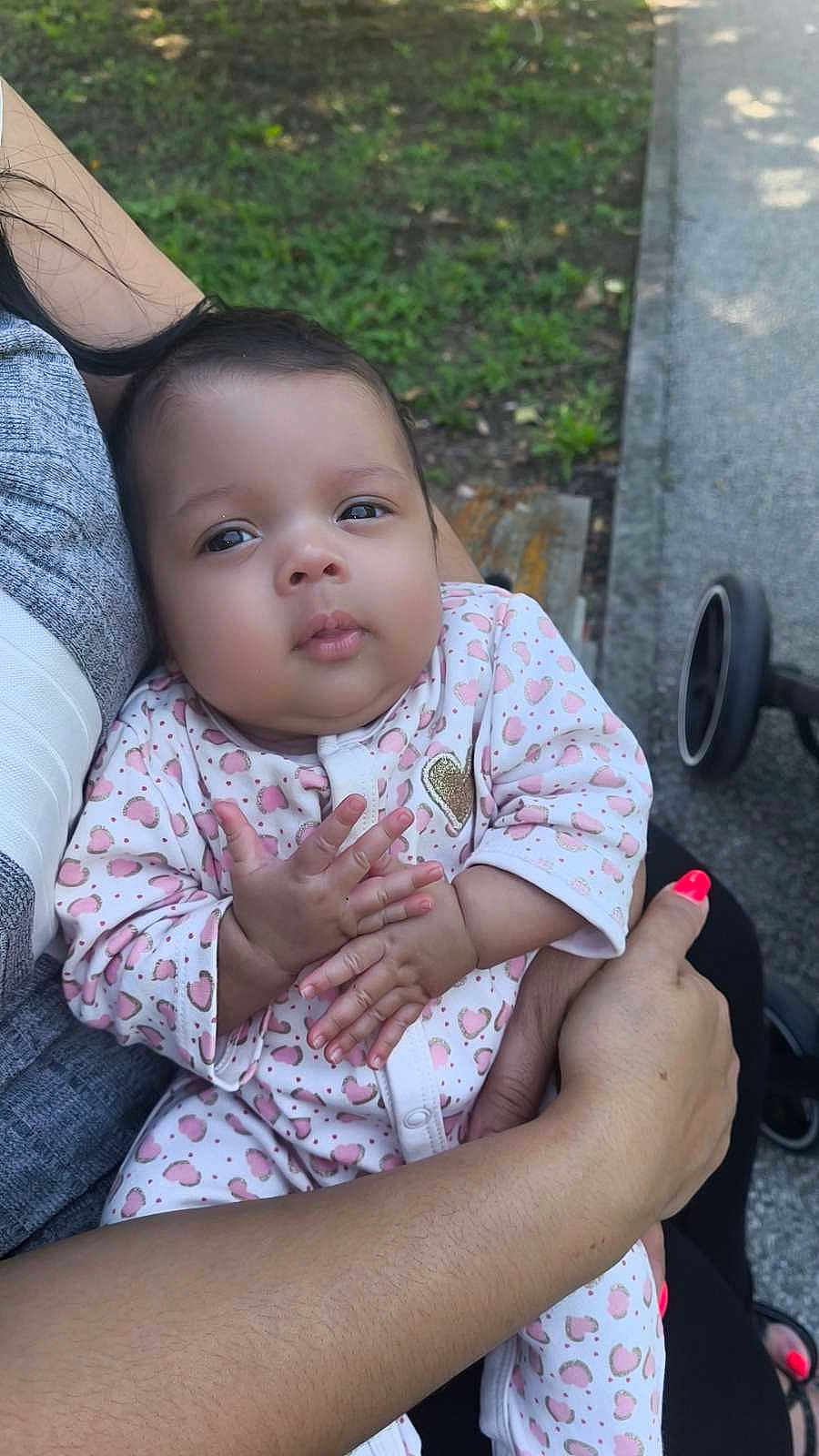 Miya a rejoint le concours — aidez-le/la à gagner de superbes lots ! baby, infant, child, person, outdoor, grass, stroller, hand, arm, clothing, onesie, heart_pattern, cute, portrait, expression, skin, nail_polish, holding, nature, relaxing