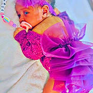 Lyric is registered to the contest to win money with this photo: baby, infant, purple_dress, bow, pacifier, beaded_clip, blanket, lying_down, cute, newborn, soft_texture, face, headband, sleepy, child, adorable, indoors, closeup, person, toddler